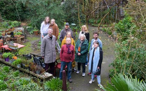 Bewoners van  De Halve Wereld op hun gemeenschappelijke middenterrein.De  wooncoöperatie uit begin jaren '80 telt uit 118 sociale huurwoningen 