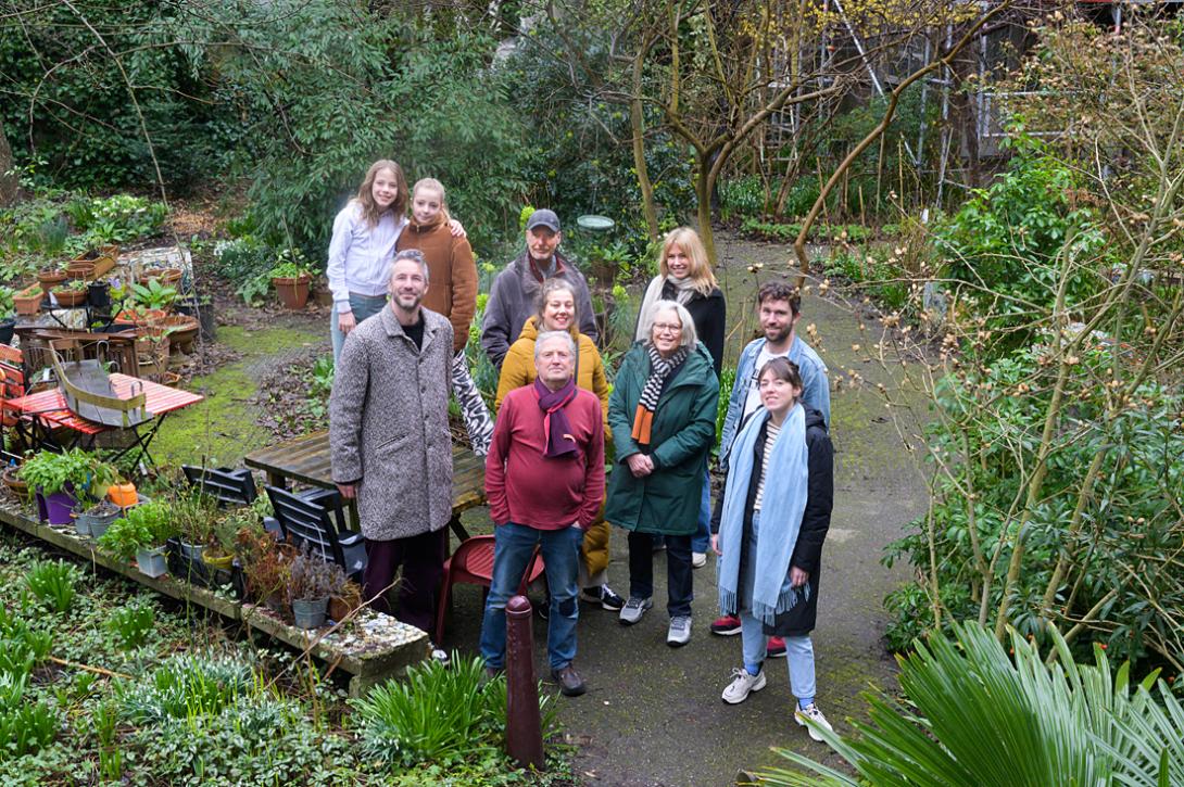 Bewoners van  De Halve Wereld op hun gemeenschappelijke middenterrein.De  wooncoöperatie uit begin jaren '80 telt uit 118 sociale huurwoningen 