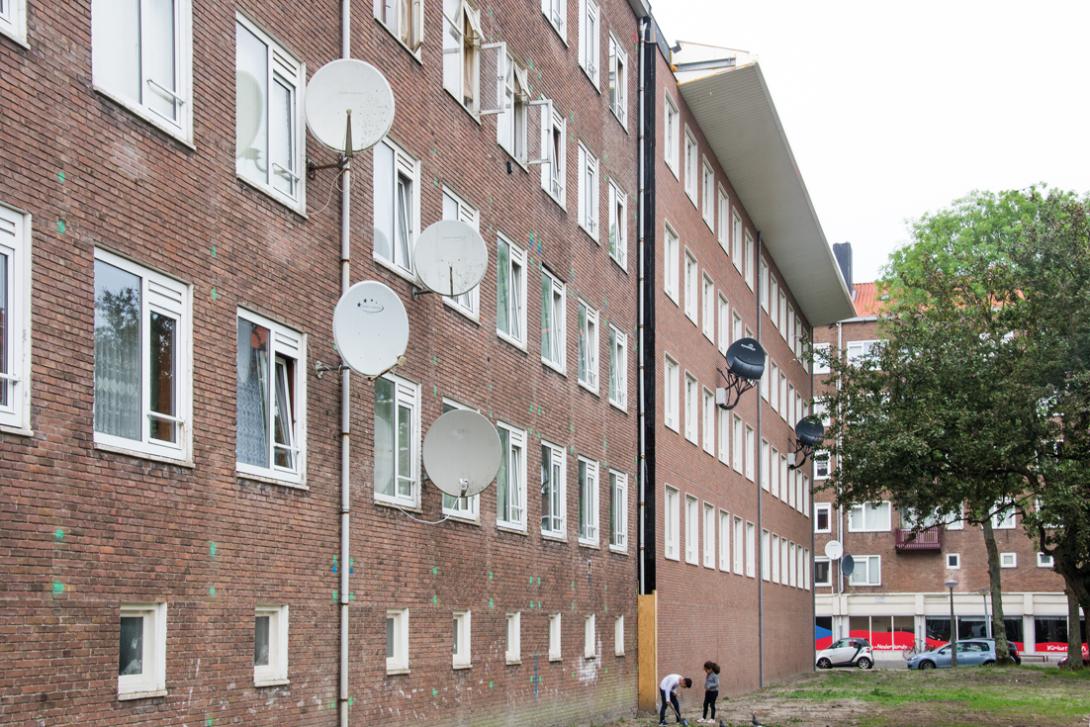 Bij de NOM-verduurzaming van de halve portiekflat is een nieuwe schil aan de buitenzijde geplaatst, inclusief nieuwe balkons en overstekende dakrand. 