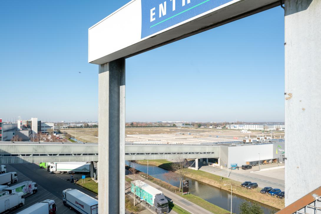 De bloemenveiling heeft Schiphol nodig. Niet zozeer om bloemen aan en af te voeren, als wel om woningbouw te voorkomen en daarmee klagende buren – Legmeerdijk, Aalsmeer.